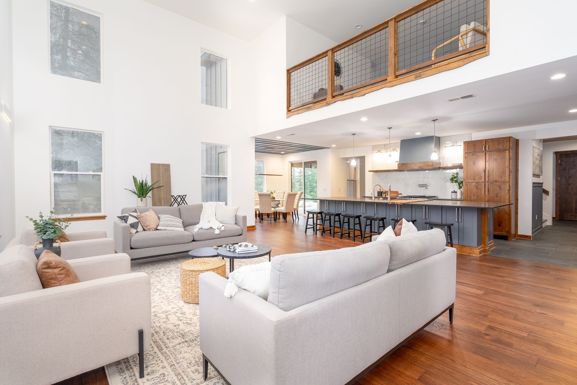 A living room with a couch , chairs , and a kitchen.