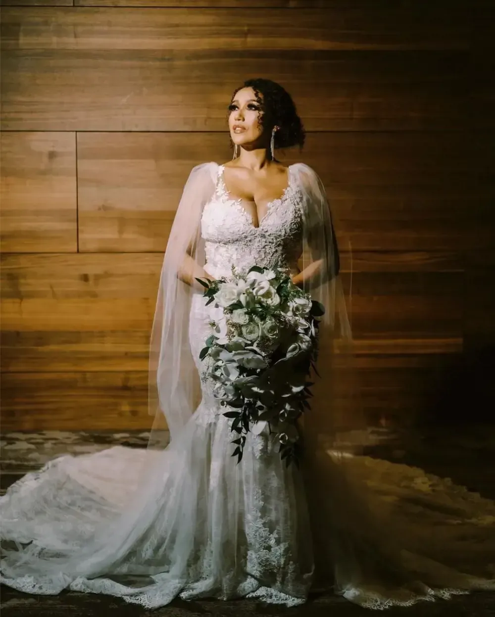 The bride is wearing a wedding dress and holding a bouquet of flowers.