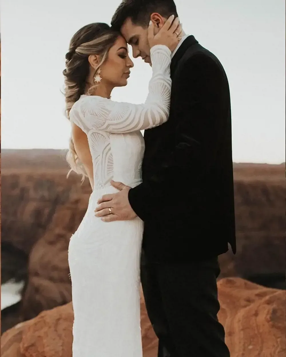 A bride and groom are hugging and looking into each other 's eyes