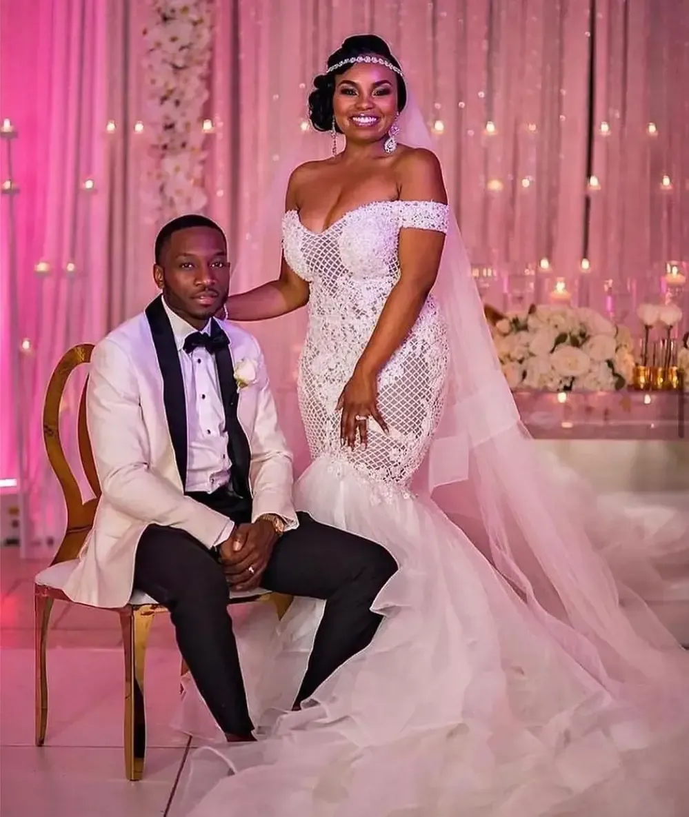 A bride and groom are posing for a picture at their wedding reception.