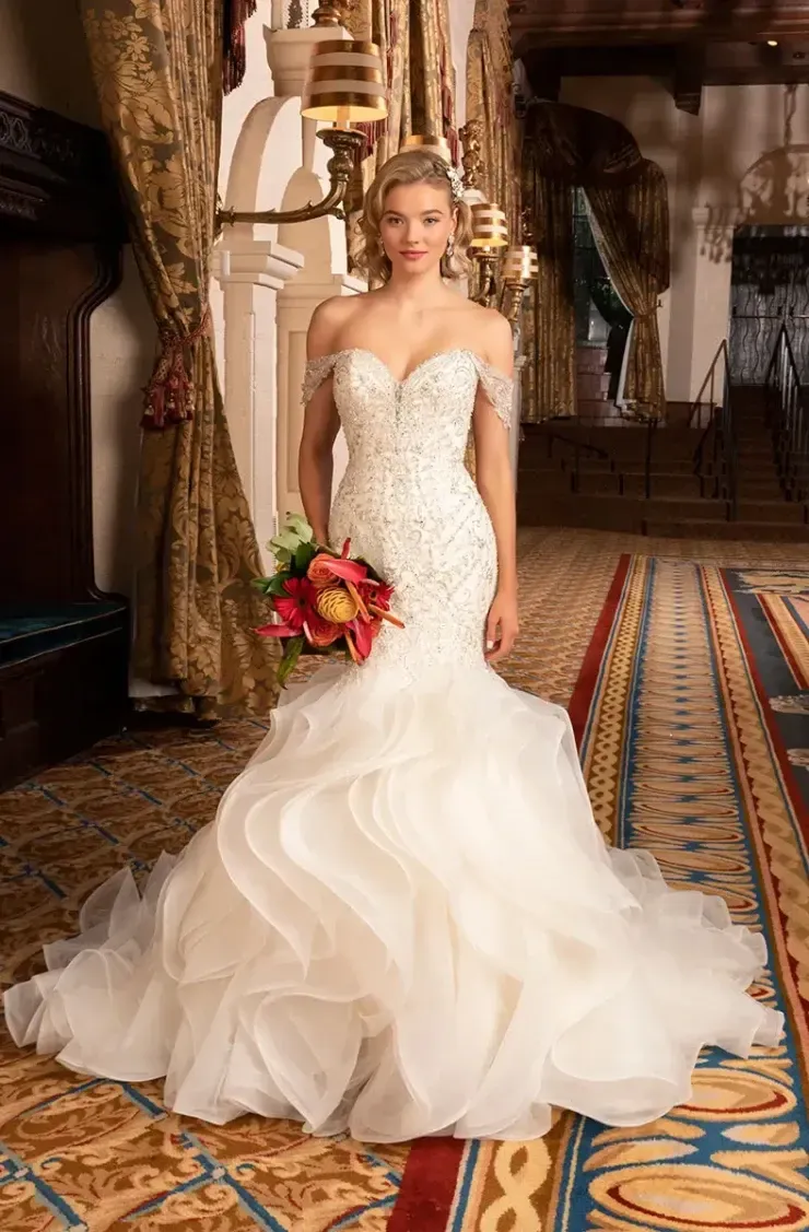 A woman in a wedding dress is holding a bouquet of flowers.