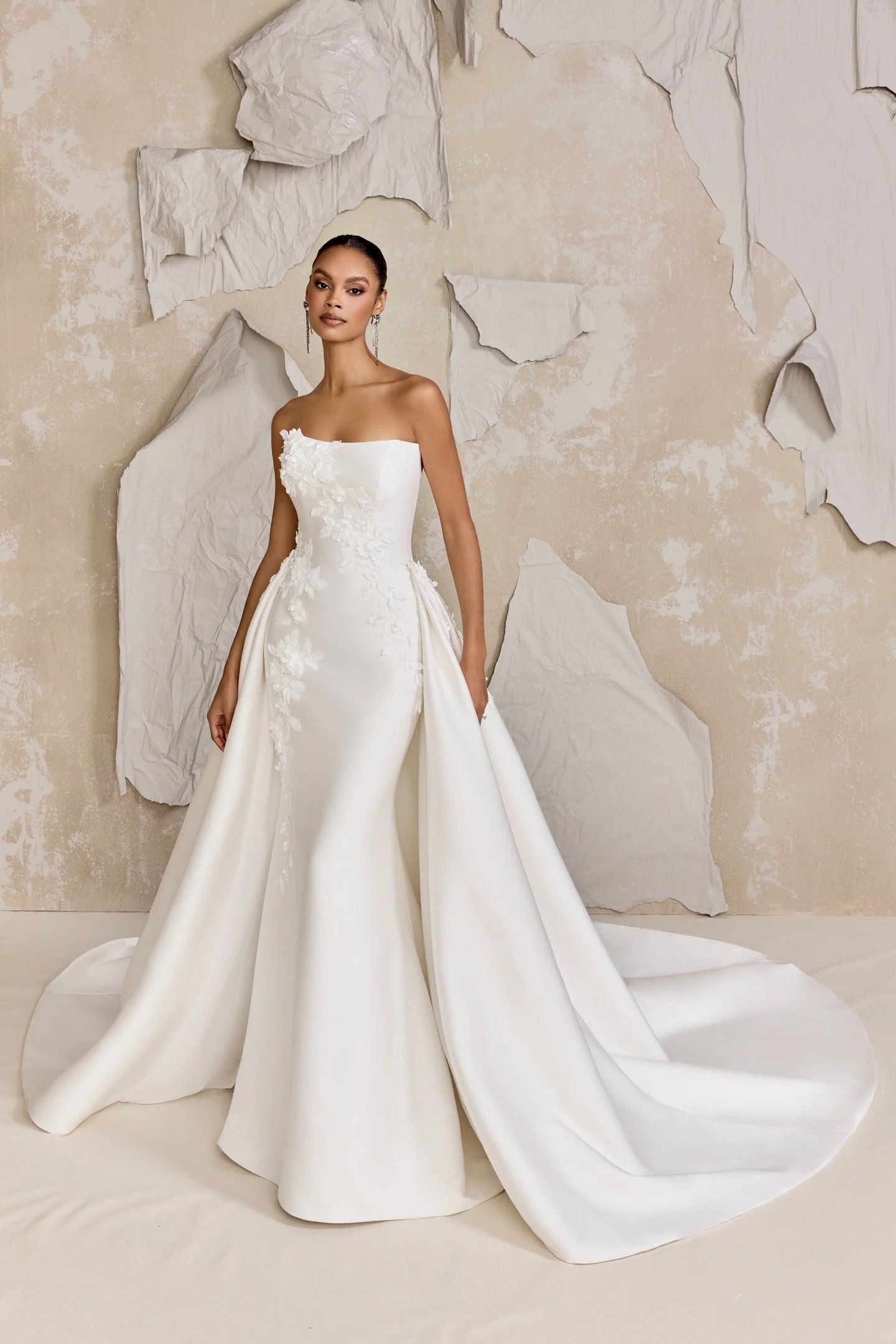 A woman is wearing a white wedding dress with a high slit.