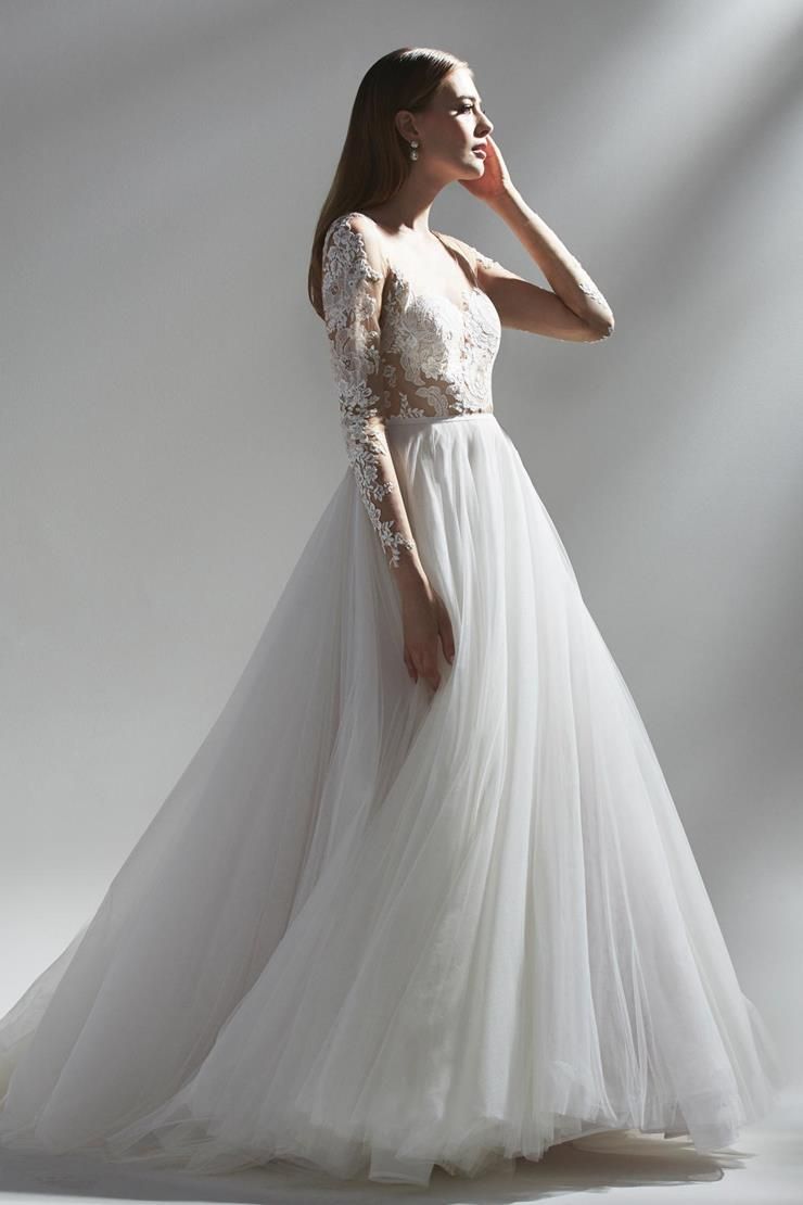 A woman is wearing a white wedding dress with long sleeves.