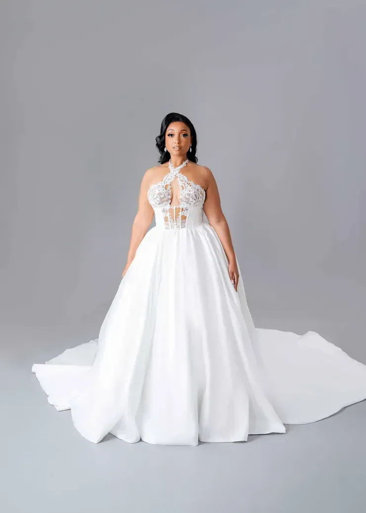 A woman is wearing a white wedding dress with a long train.