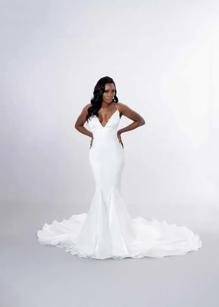 A woman is wearing a white wedding dress with a long train.
