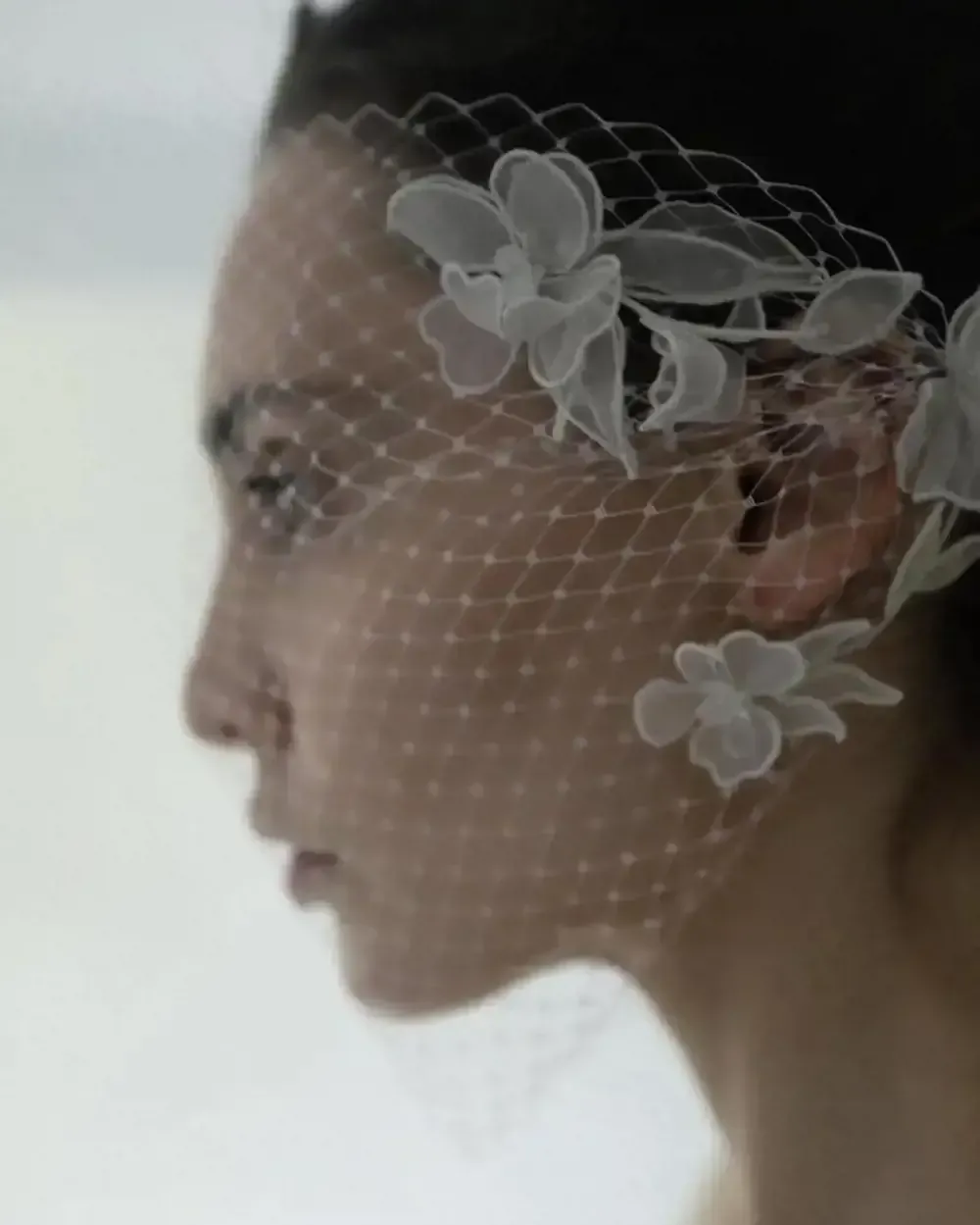 A woman wearing a veil with white flowers on it