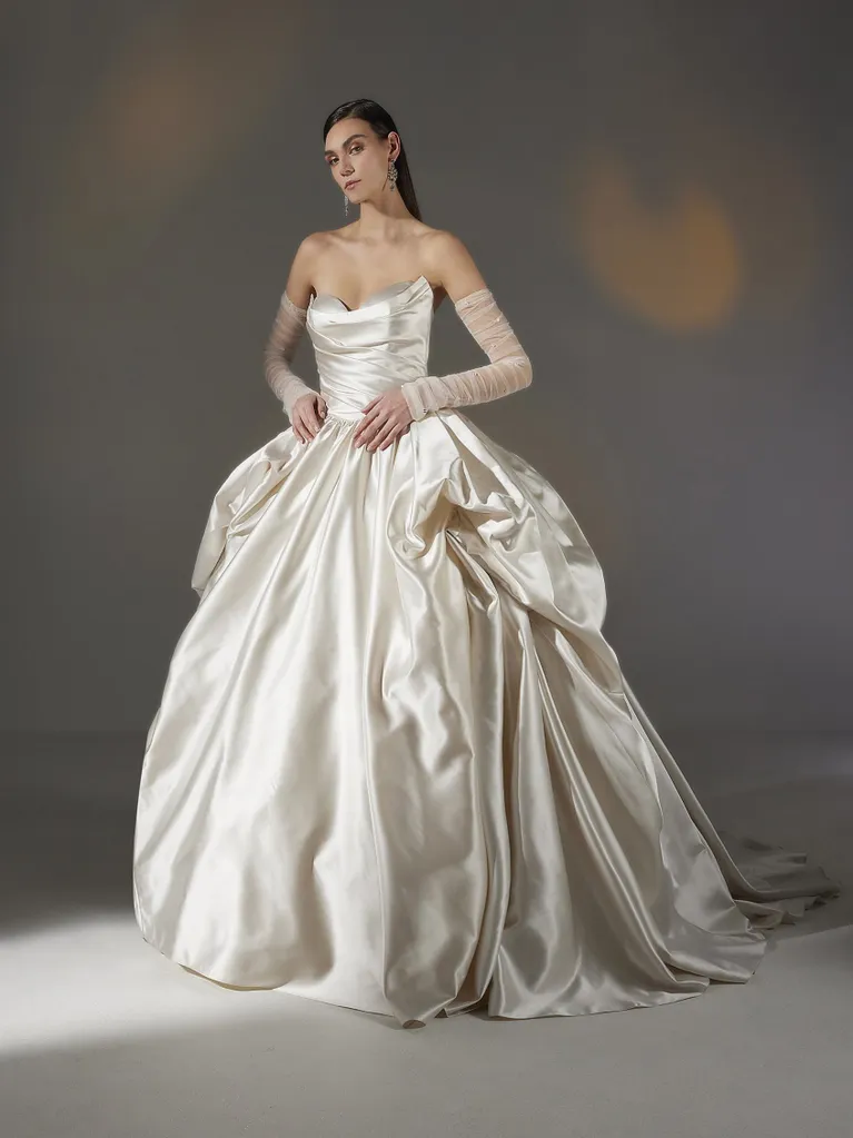 Woman in a strapless ivory satin ball gown with pearl accents and elbow-length gloves.