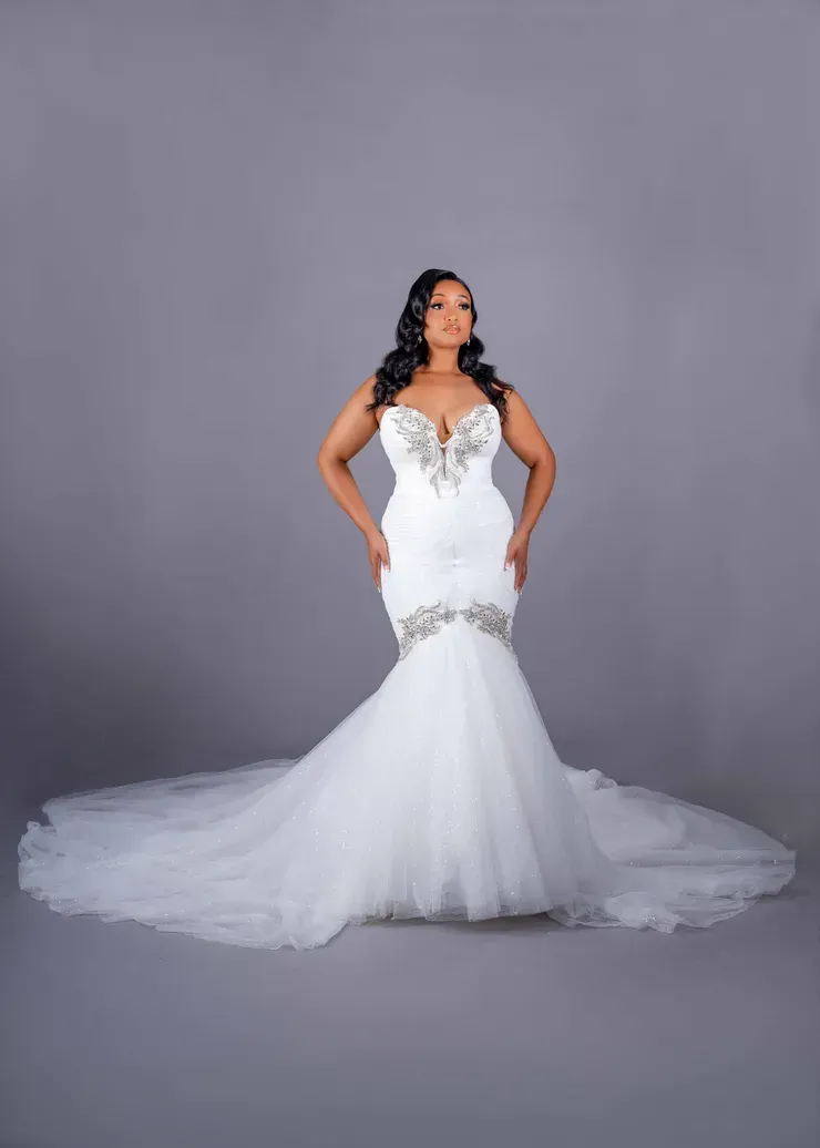 A woman is wearing a white wedding dress with a long train.