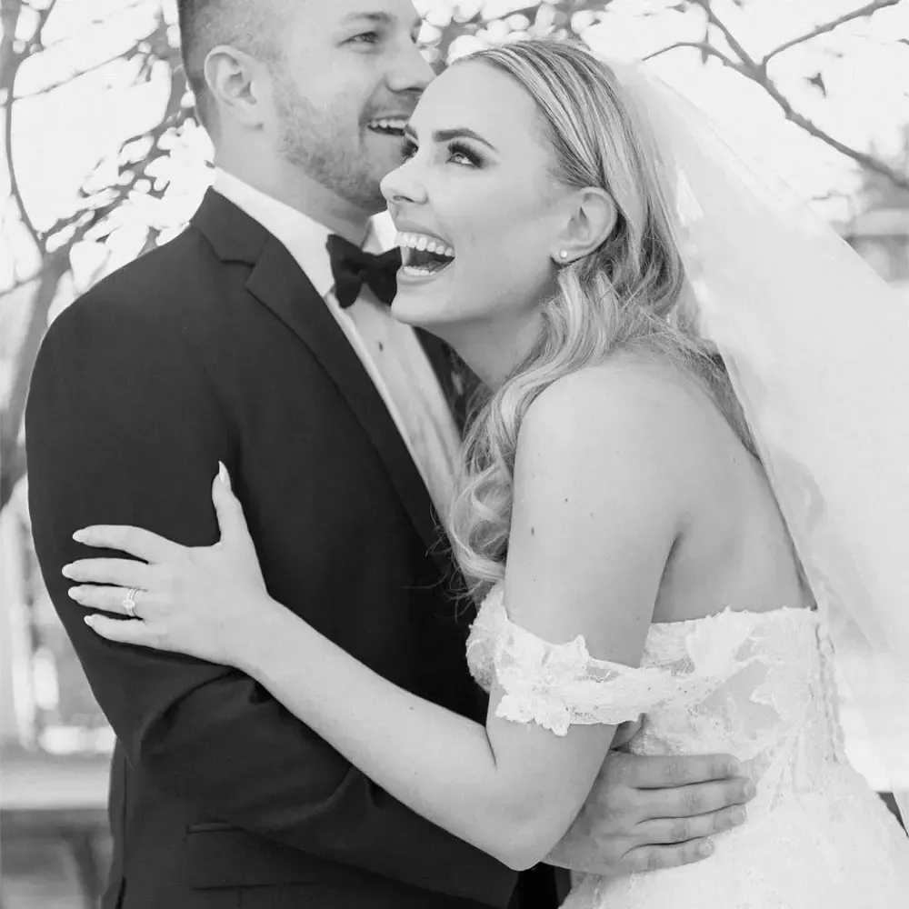 A black and white photo of a bride and groom hugging