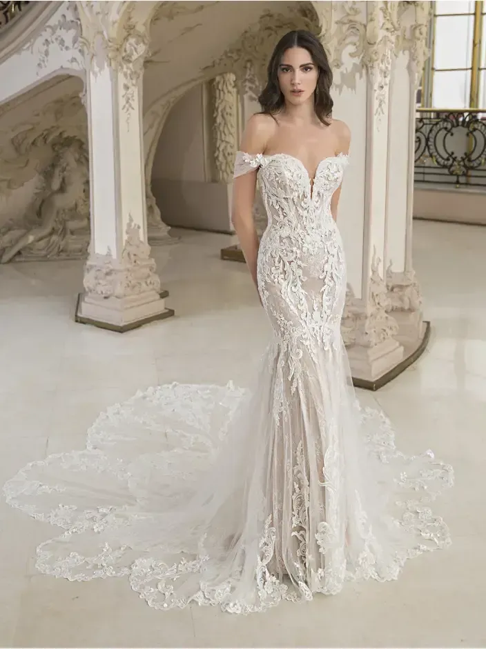 A woman in a wedding dress is standing in front of a staircase.