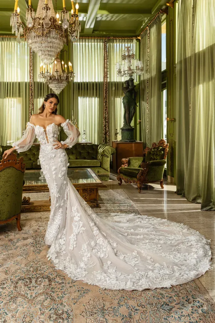 A woman in a wedding dress is standing in a living room.