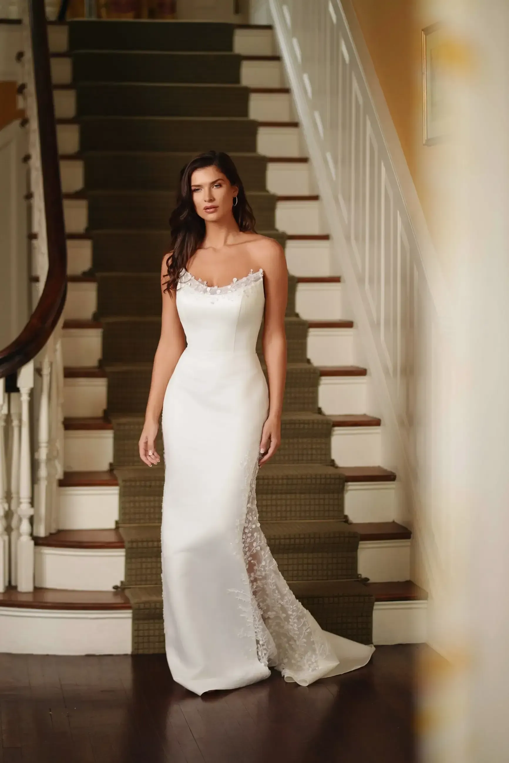 A woman in a wedding dress is standing on a set of stairs.