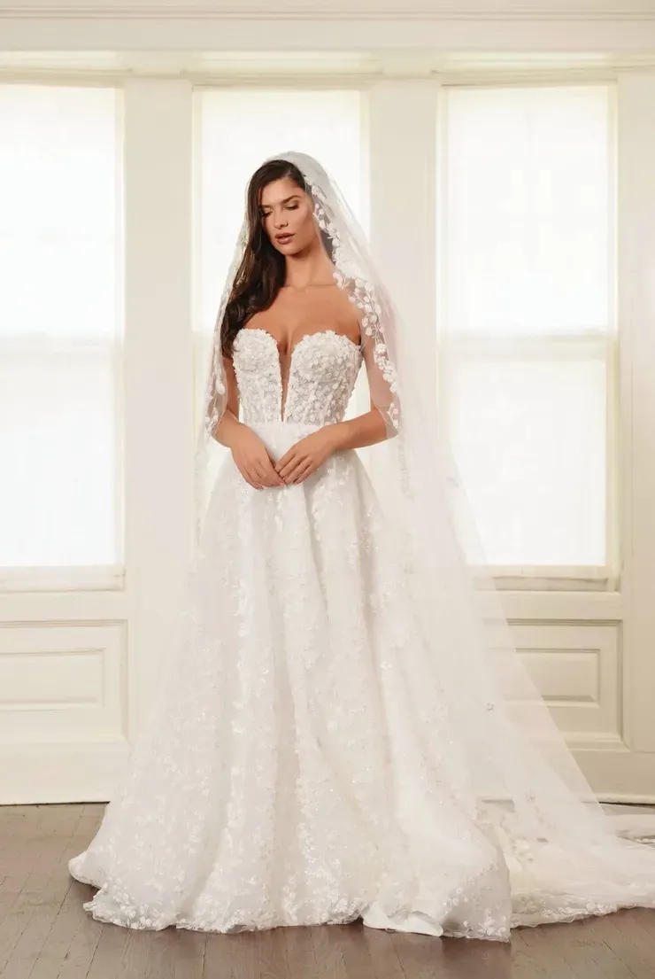 A woman is wearing a white wedding dress and veil.