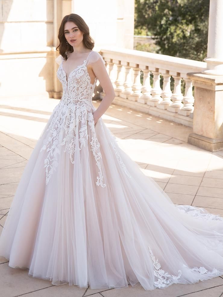 A woman is wearing a white wedding dress with a long train.