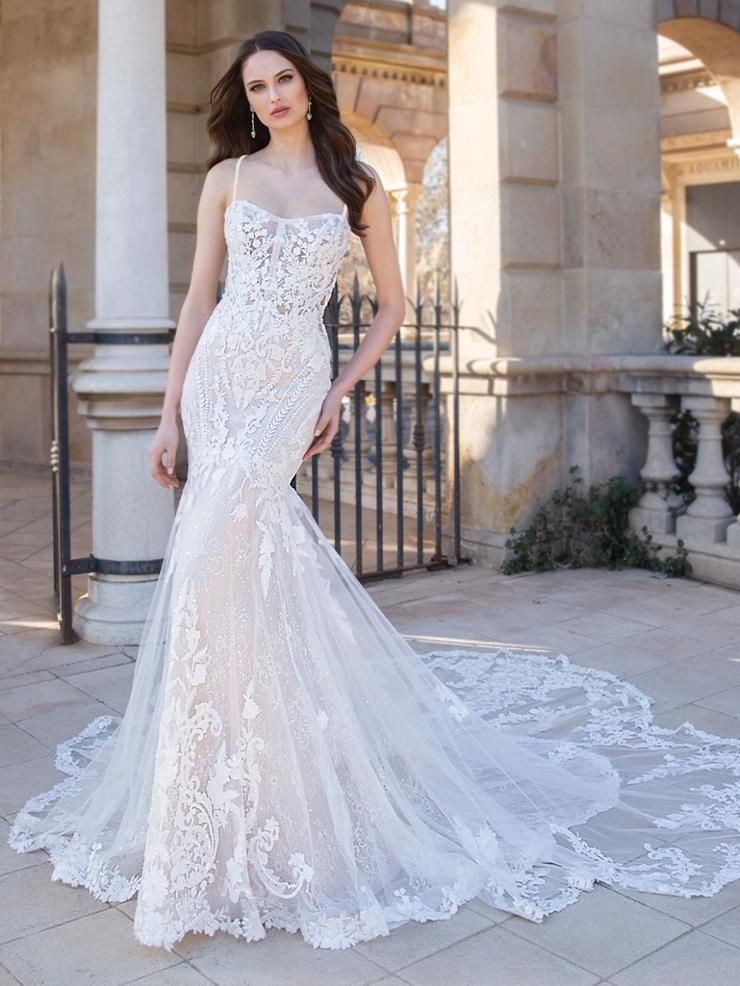 A woman in a wedding dress is standing in front of a building.