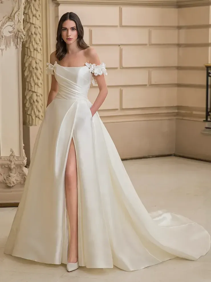 A woman is wearing a white wedding dress with a high slit.