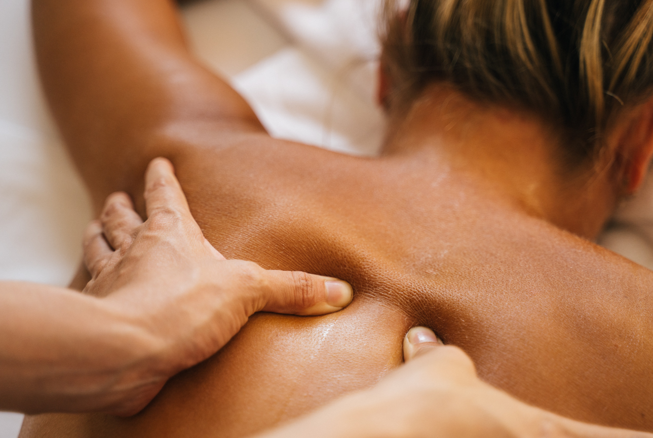 A woman is getting a massage on her back at a spa.