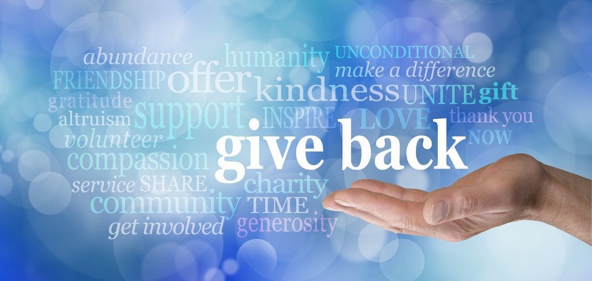 A hand is reaching out towards the word give back.