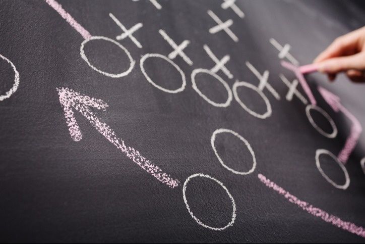 A person is writing on a blackboard with chalk