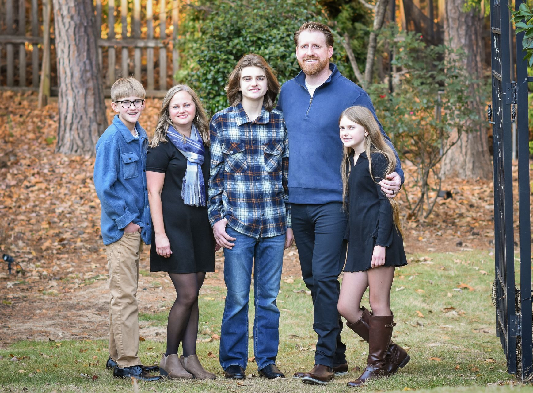 A family is posing for a picture in front of a field.