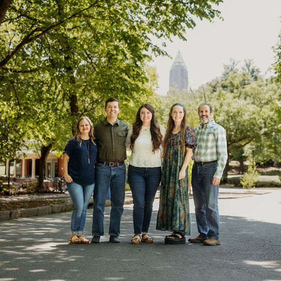 A group of people are posing for a picture in a park.