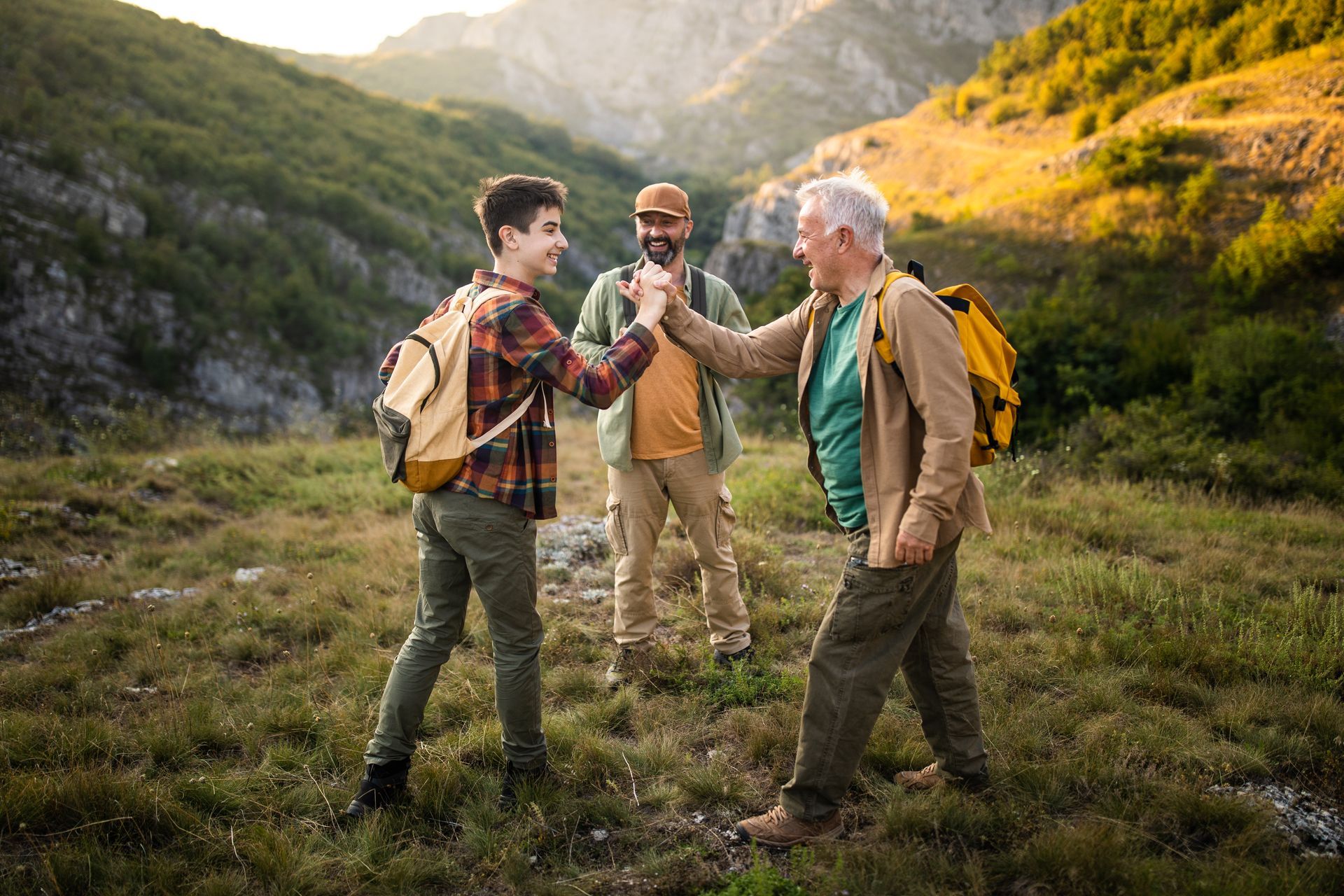 A group of people are hiking in the mountains and shaking hands.