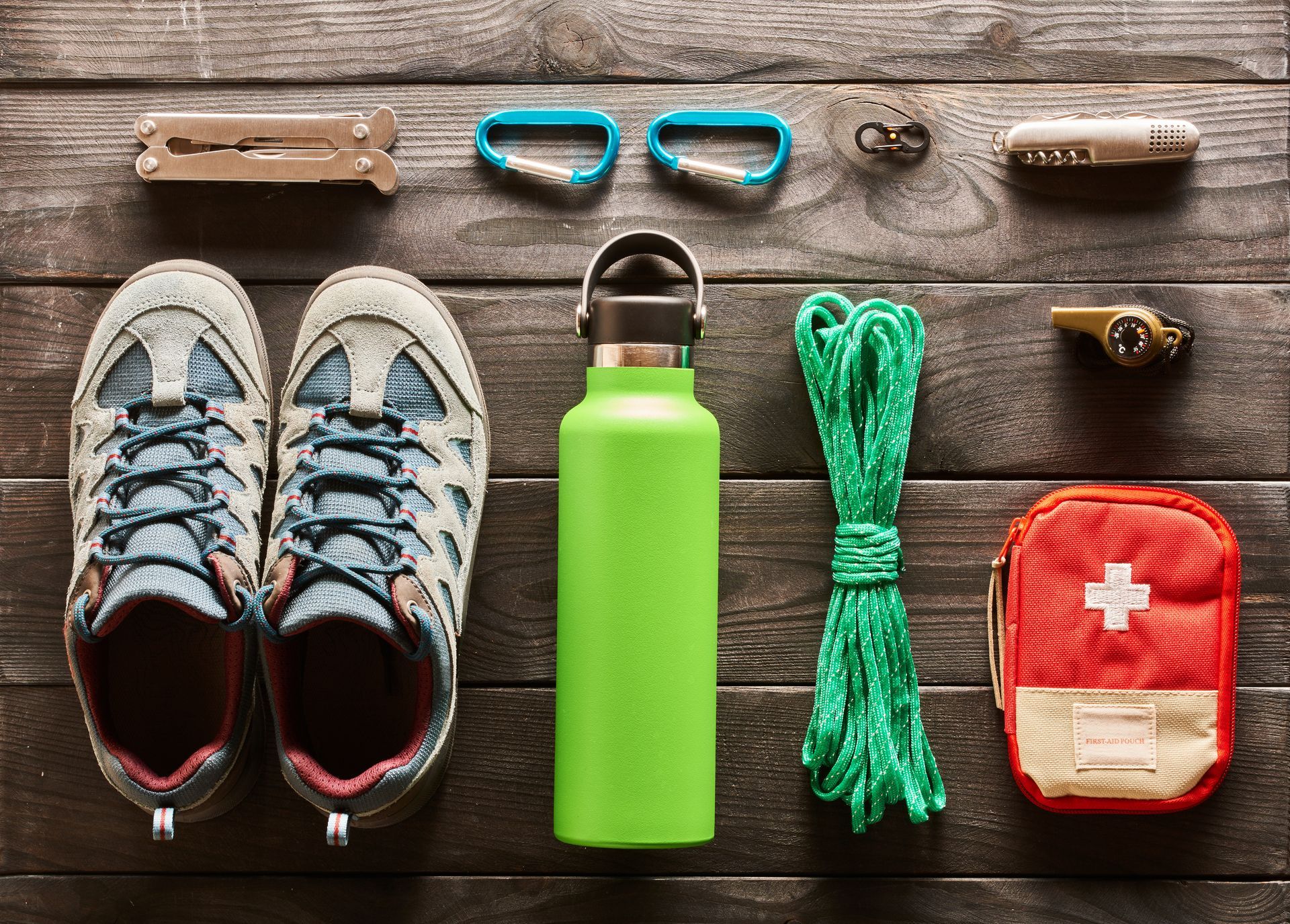 Different climbing and first aid supplies are laid out on a wooden table.