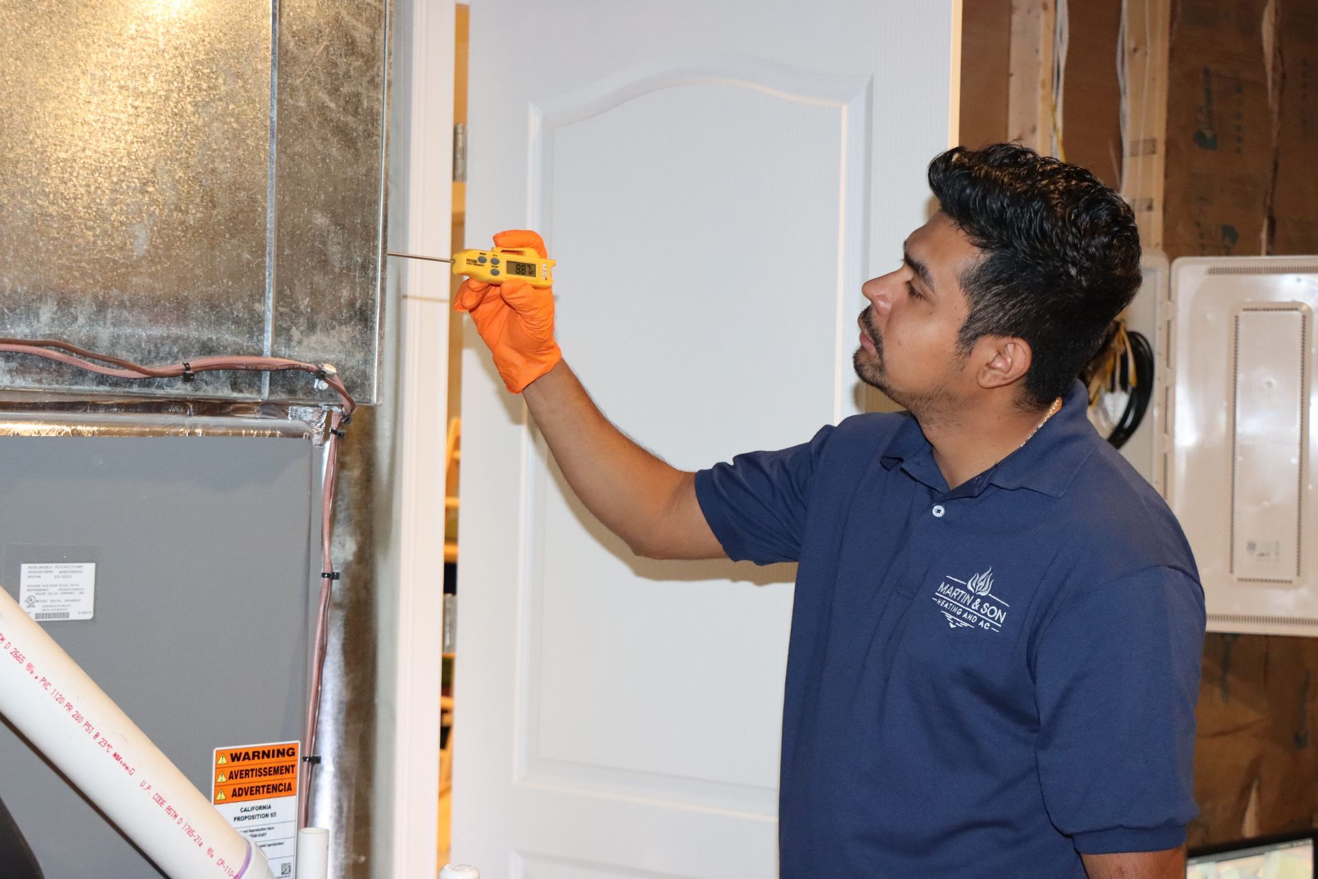 AC technician connecting pipes to an outdoor air conditioning unit.