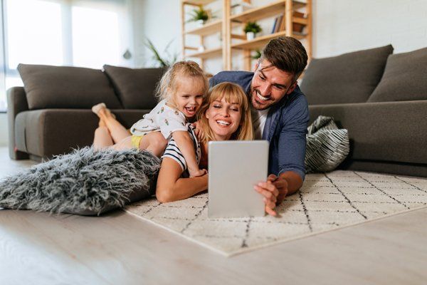 A Happy Family Looking on a Tablet — Boone NC — Boone Heating & Air Conditioning Inc A Happy Family Looking on a Tablet — Boone NC — Boone Heating & Air Conditioning Inc