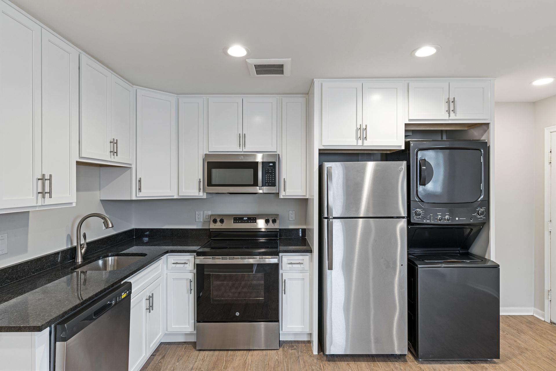 A kitchen with stainless steel appliances and white cabinets.