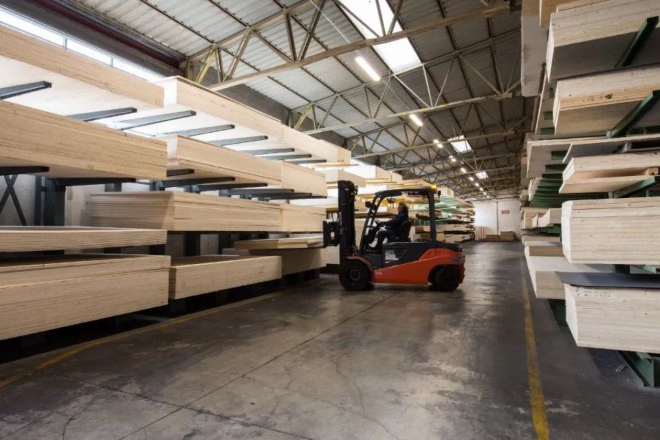operatore su carrello elevatore che solleva pannelli in legno