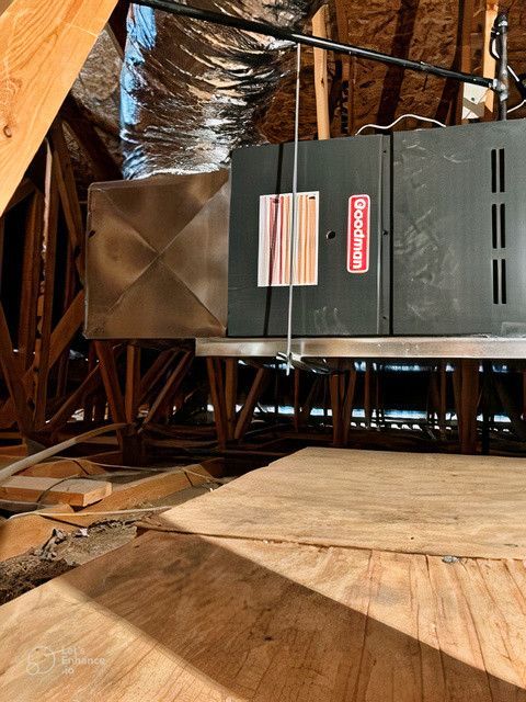 An air conditioner is hanging from the ceiling in an attic