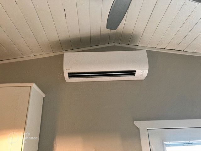 A room with a ceiling fan and a wall mounted air conditioner.