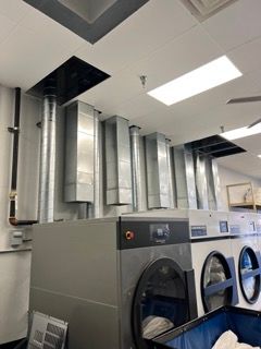 A laundromat with a lot of washers and dryers.