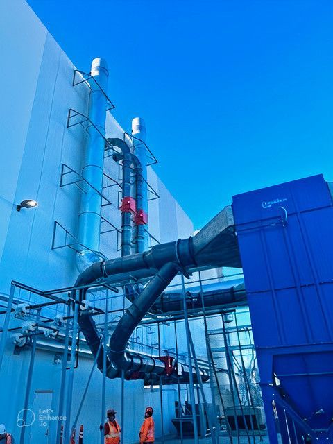 A blue building with a lot of pipes coming out of it