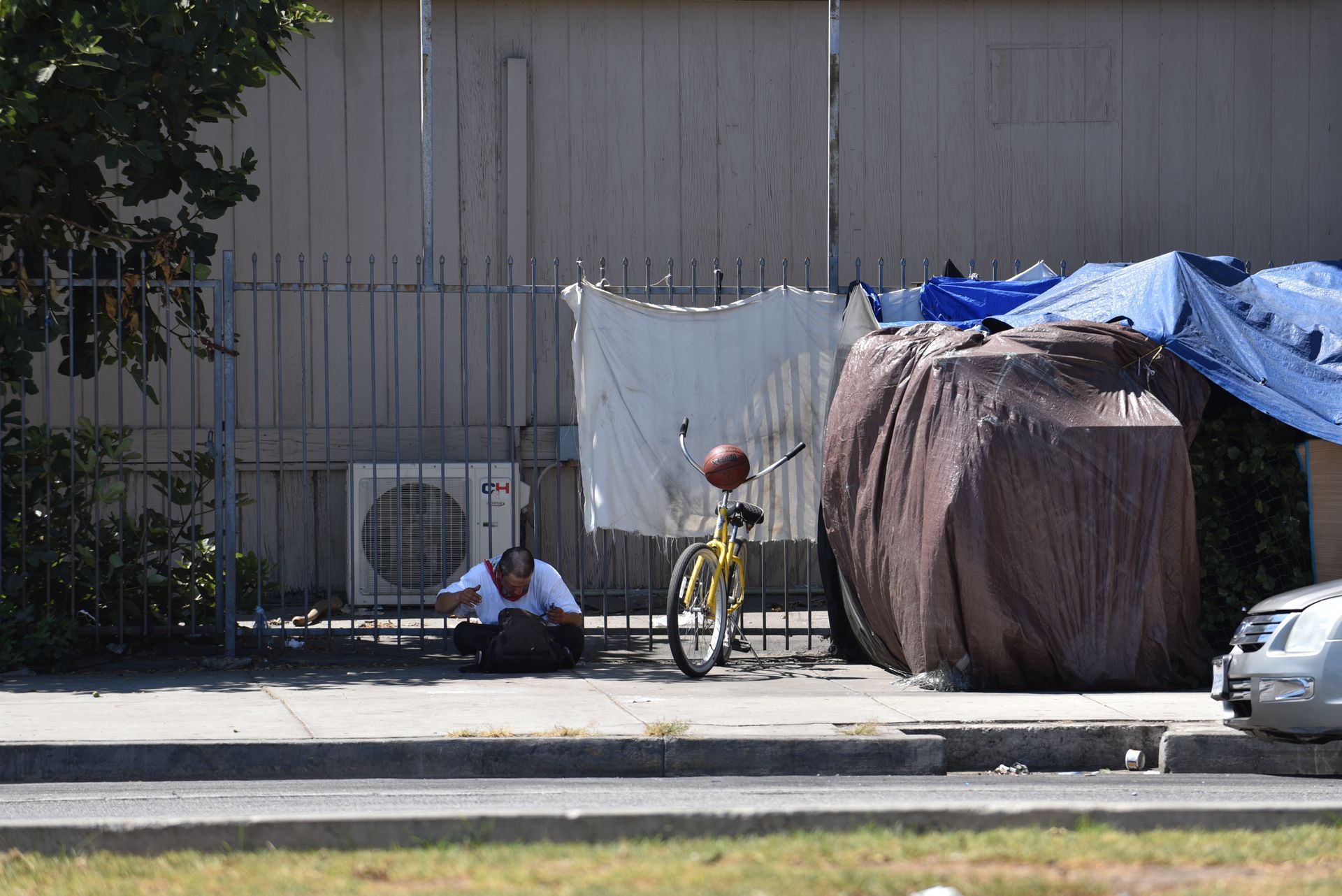 Homeless man and tent under a freeway on ramp on Venice Boulevard