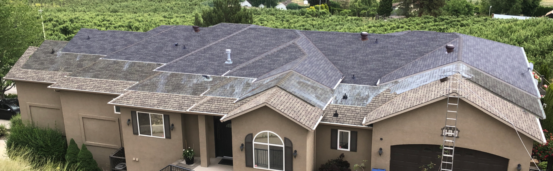 An aerial view of a large house with a roof that is covered in shingles.