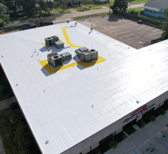 Multi-colored stone patio next to a red brick house and lawn.