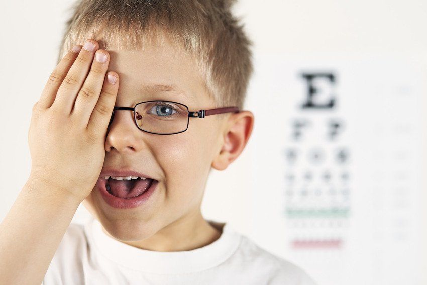 Child covering right eye for test
