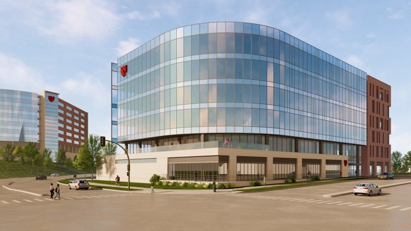 Modern glass and brick office building on a street corner, sunny day.