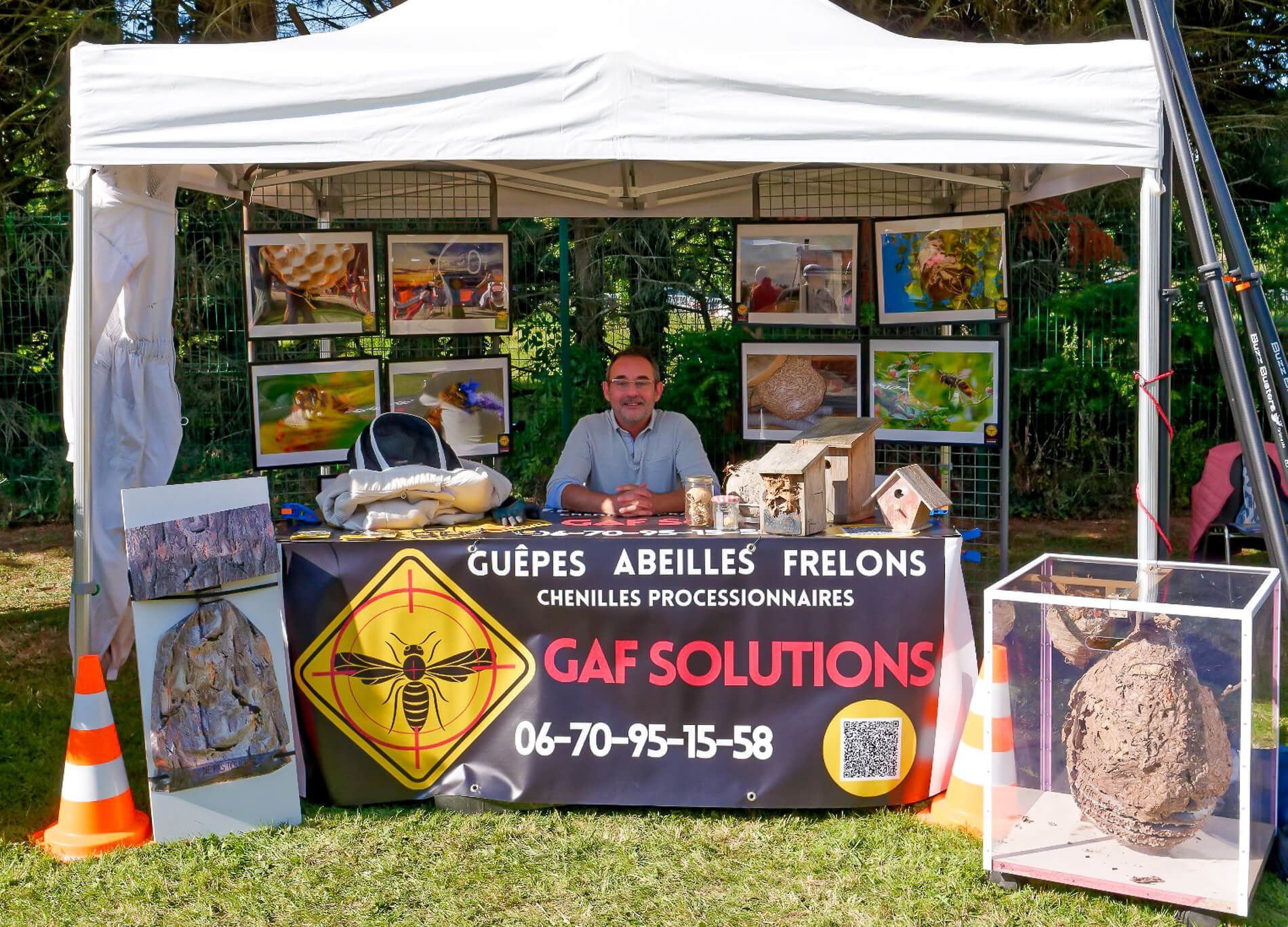 Un homme est assis à une table avec une pancarte indiquant des solutions gaf