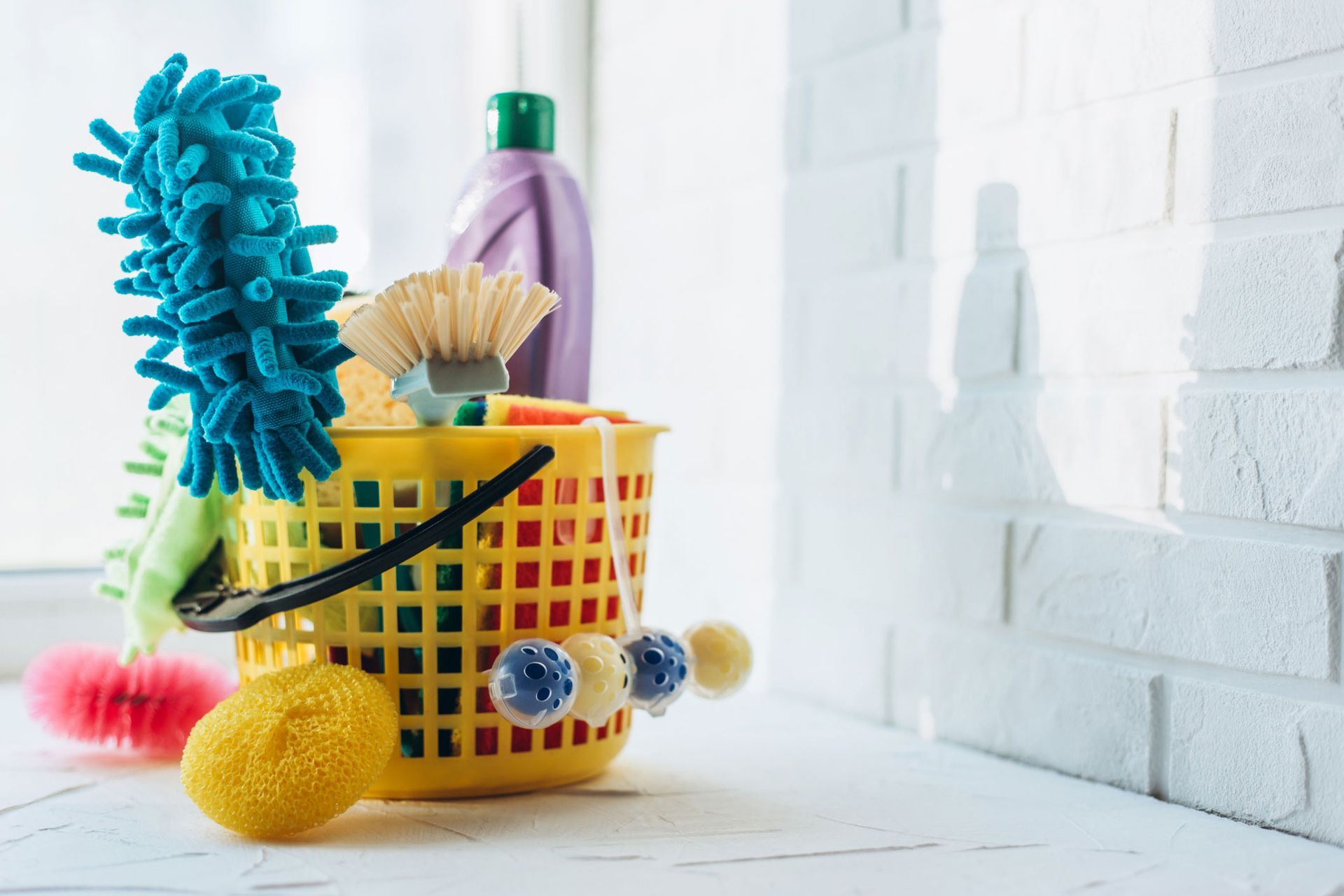 A basket filled with cleaning supplies is sitting on a table.