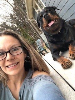 A woman is taking a selfie with her Rottweiler