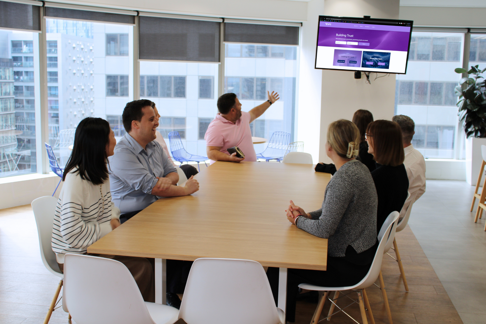 A group of people are sitting around a table in a conference room.