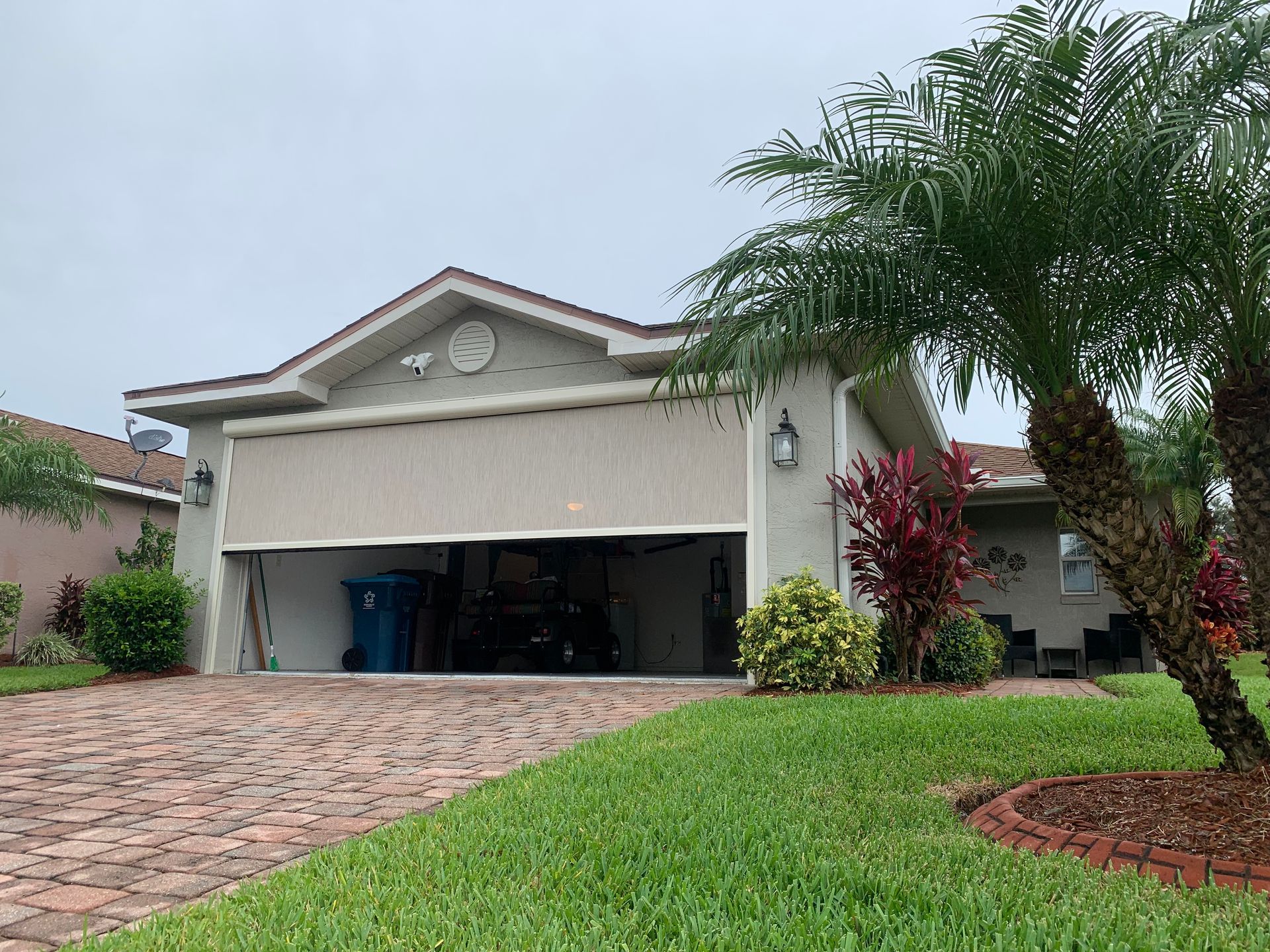 A house with a garage and a palm tree in front of it