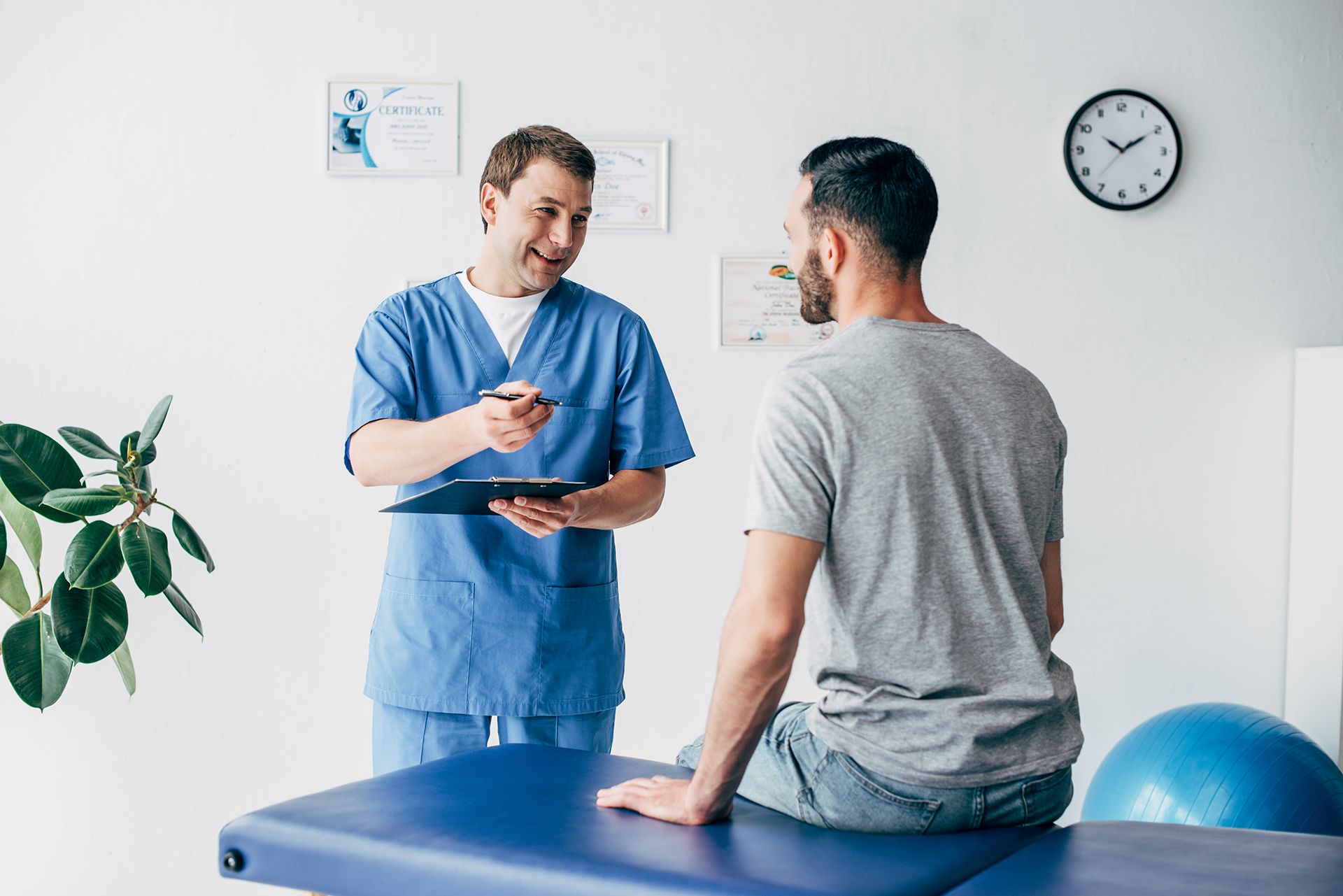 A doctor is talking to a patient who is sitting on a table.