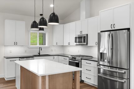 Bright modern kitchen with white cabinets, stainless appliances, and a large island