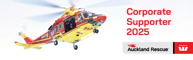 A red and yellow helicopter is flying in the sky.