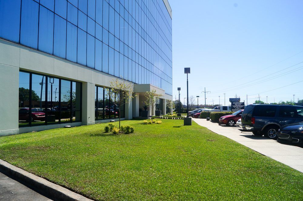 A large building with a lot of windows and cars parked in front of it