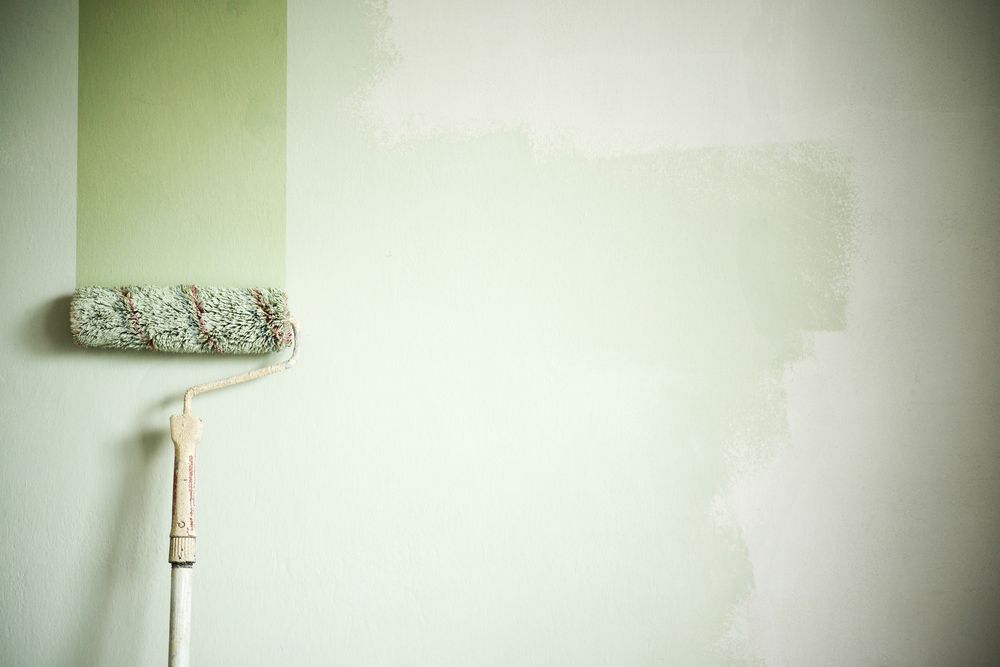 A paint roller is painting a wall green — Prota NT in Howard Springs, NT